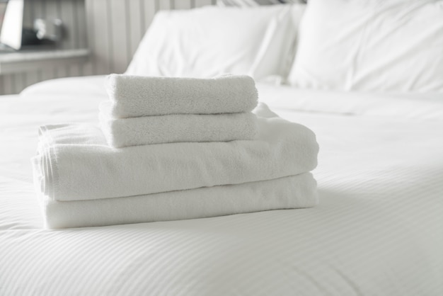 Bianco asciugamano sulla decorazione letto in camera da letto interni