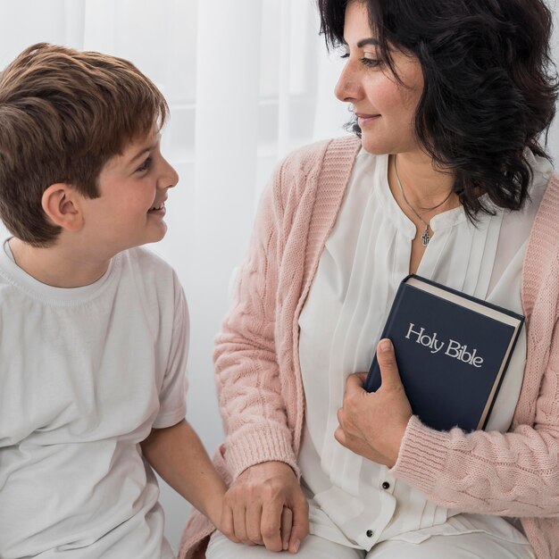 Bibbia della holding della donna con il suo bambino