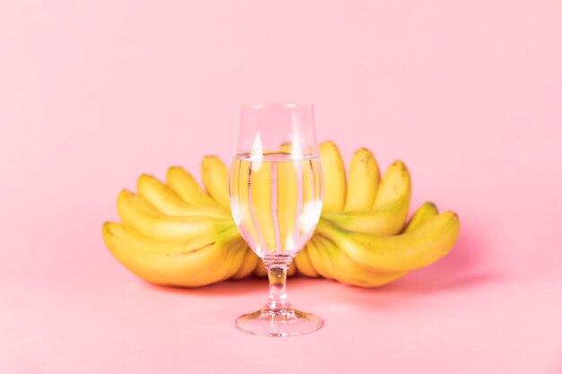 Bicchiere d'acqua con le banane nel fondo