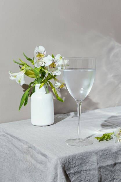 Bicchiere d'acqua e fiori sul tavolo