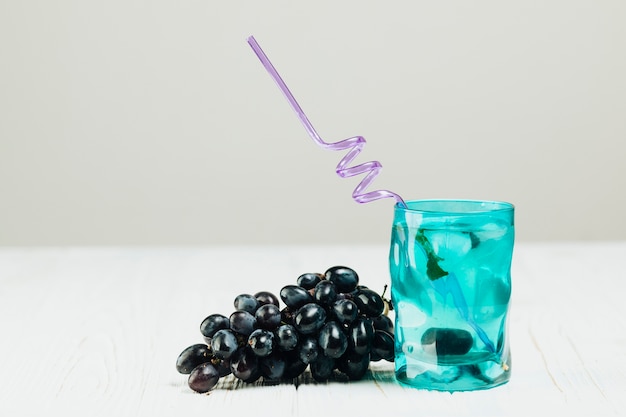 Bicchiere d'acqua ed uva su fondo normale
