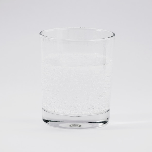 Bicchiere d&#39;acqua su sfondo grigio