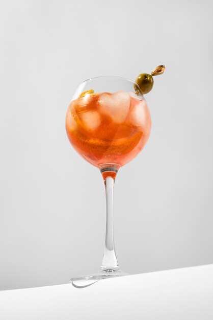 Bicchiere da cocktail con cubetti di ghiaccio e oliva