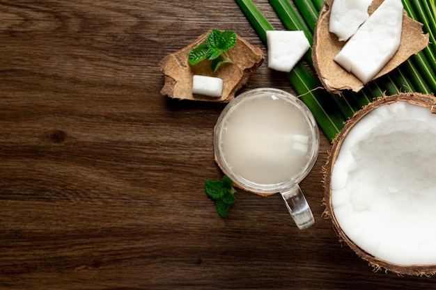 bicchiere di acqua di cocco messo su fondo in legno scuro