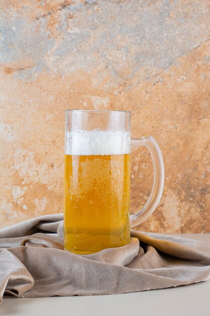 Bicchiere di birra dorata fredda isolato su una tovaglia leggera