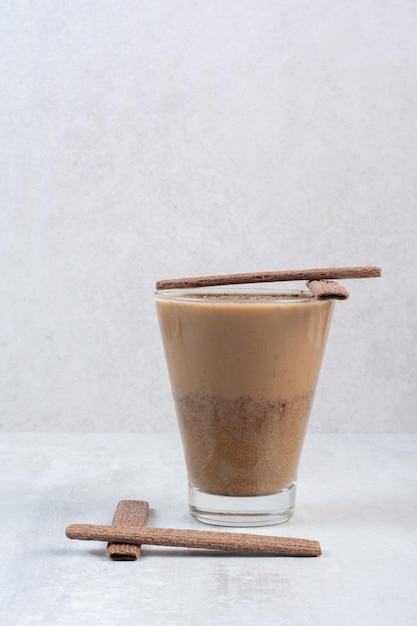 Bicchiere di caffè con biscotti stick su sfondo grigio. Foto di alta qualità