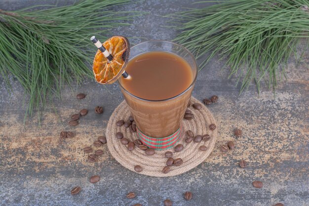 Bicchiere di caffè con paglia e fetta d'arancia. Foto di alta qualità