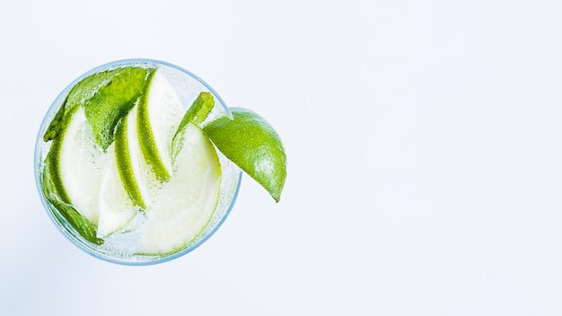 Bicchiere di cocktail con fette di lime e menta piperita