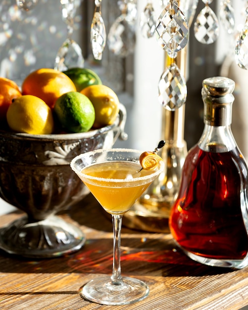 Bicchiere di cognac e una ciotola di frutta sul tavolo