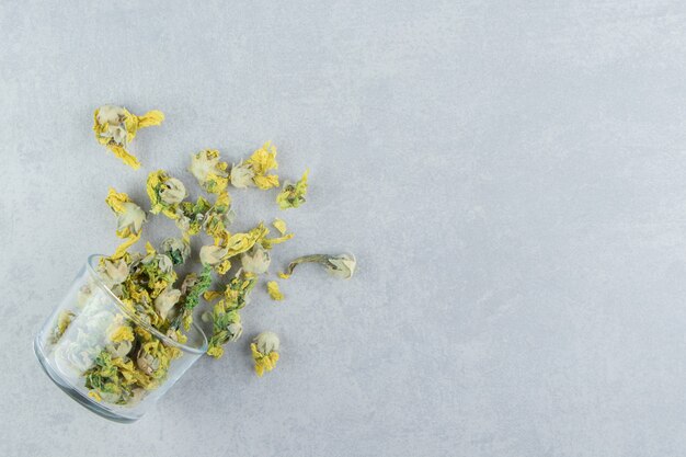 Bicchiere di fiori di crisantemo secco sul tavolo di pietra.