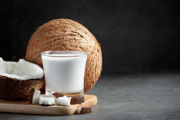 bicchiere di latte di cocco messo sul tagliere di legno