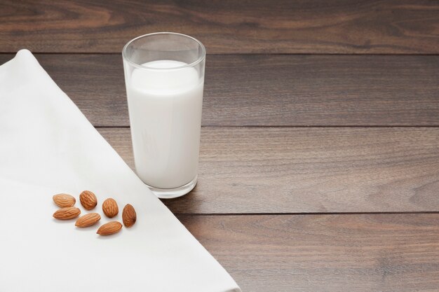 Bicchiere di latte di mandorle su fondo in legno