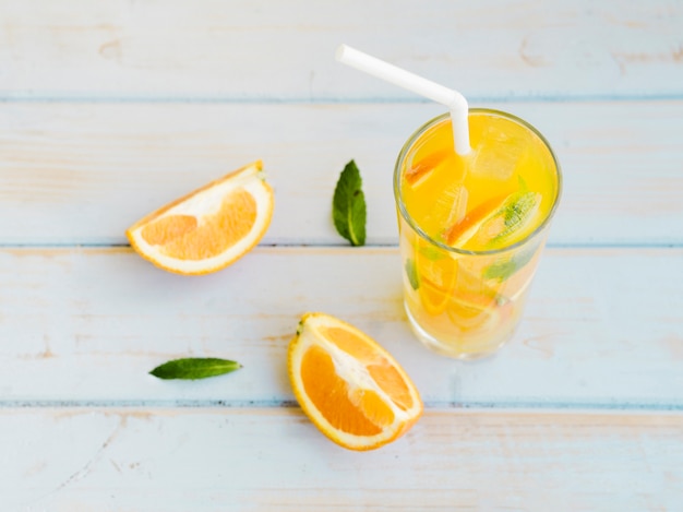Bicchiere di succo d&#39;arancia ghiacciato con fette e paglia