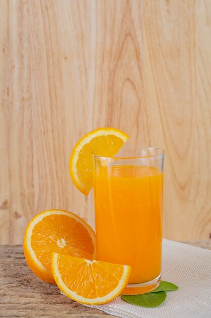 Bicchiere di succo d&#39;arancia posto su legno.
