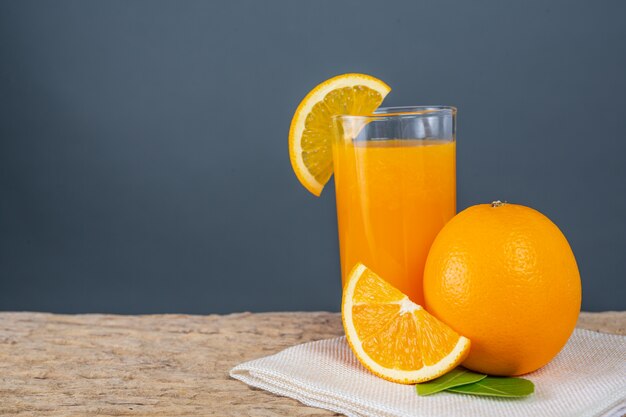 Bicchiere di succo d&#39;arancia posto su legno.
