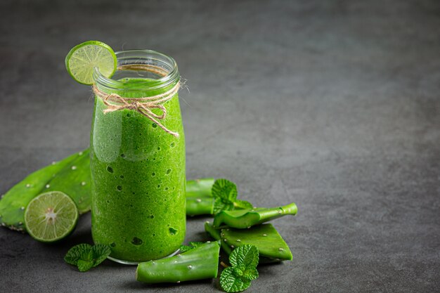 bicchiere di succo di aloe vera messo sul pavimento scuro