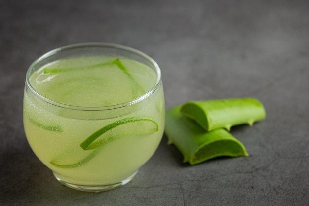 bicchiere di succo di aloe vera messo sul pavimento scuro