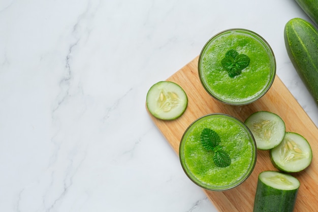 Bicchiere di succo di cetriolo fresco su fondo di marmo