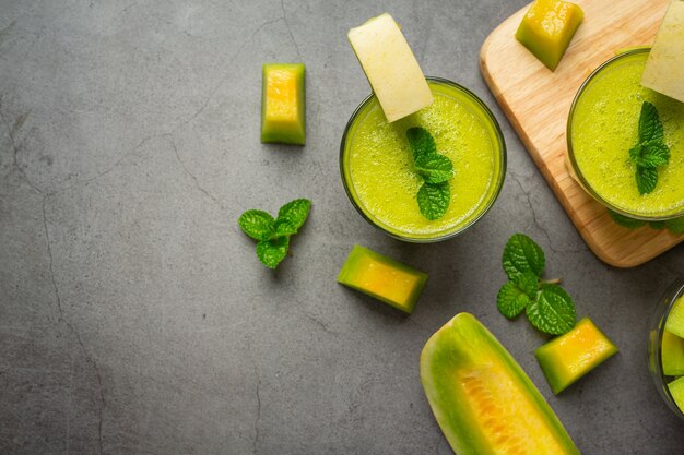 bicchiere di succo di melone messo sul pavimento scuro