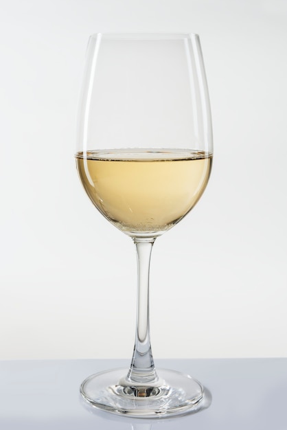 Bicchiere di vino bianco su sfondo bianco