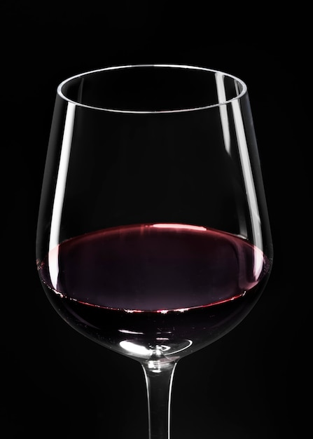 Bicchiere di vino con vino rosso su sfondo nero