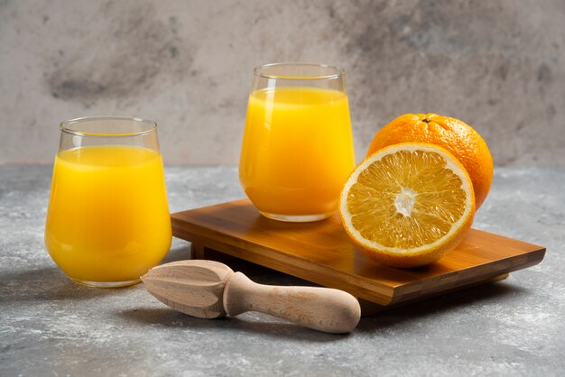 Bicchieri di vetro di succo d'arancia e un alesatore di legno.