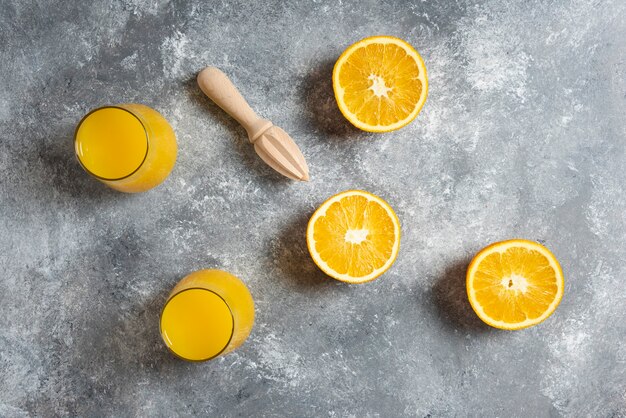 Bicchieri di vetro di succo d'arancia e un alesatore di legno.