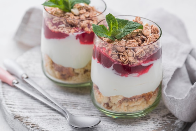 Bicchieri di yogurt con cereali e cucchiai