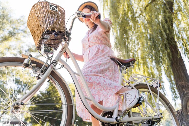 Bici di guida della donna elegante del primo piano