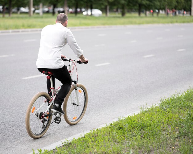 Bicicletta di guida dell'uomo d'affari sulla strada