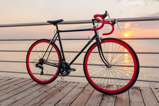 Bicicletta hipster in alba di mattina in riva al mare