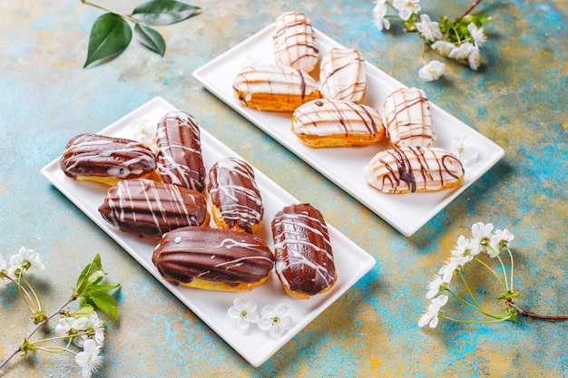 Bignè o profiteroles al cioccolato nero e bianco con crema pasticcera all'interno, dessert francese tradizionale.