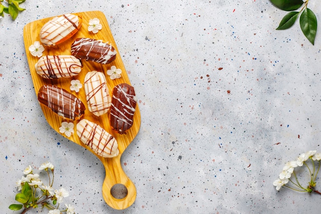 Bignè o profiteroles al cioccolato nero e bianco con crema pasticcera all'interno, dessert francese tradizionale.