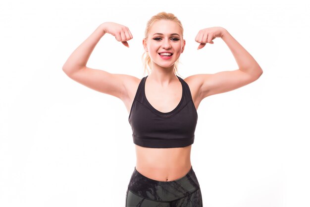 Bionda bella fitnessgirl nella parte superiore dello sport dimostra i suoi muscoli
