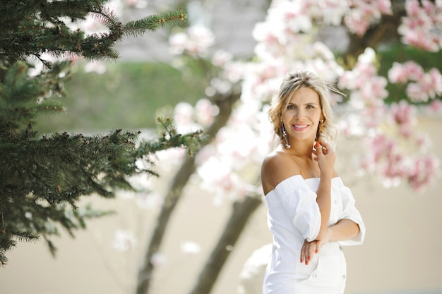 Bionda concepita in un vestito bianco nel parco