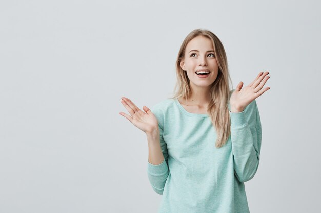 bionda eccitata bella giovane donna con i capelli lunghi sembra con grande sorpresa