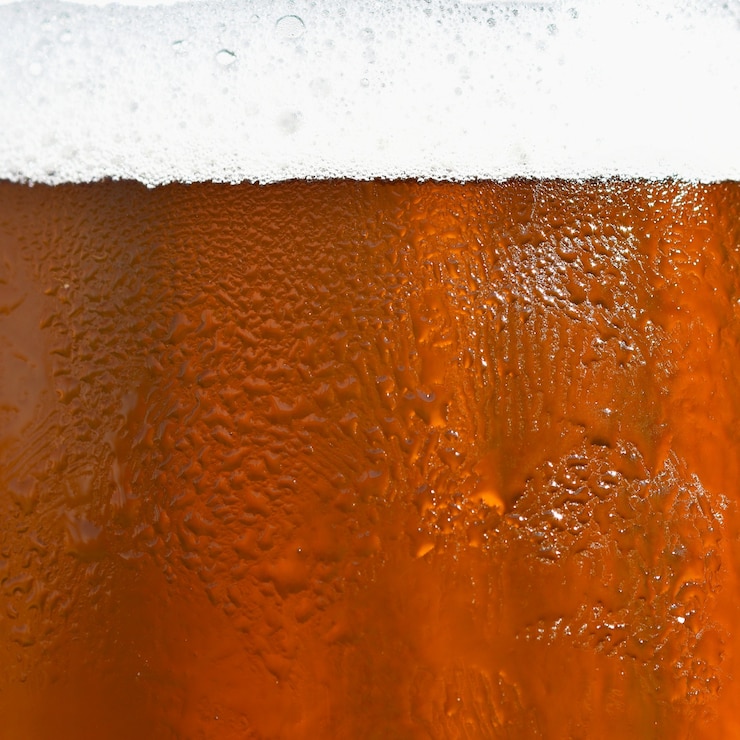 Foto gratuito birra. bellissimo dettaglio di birra battuta di birra con schiuma. sfondo colorato astratto.