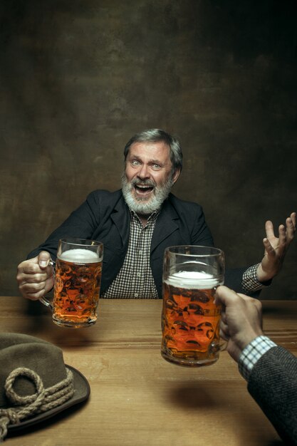 Birra bevente maschio barbuta sorridente in pub