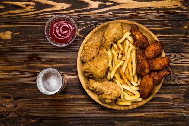 Birra e salsa vicino a pollo e patate