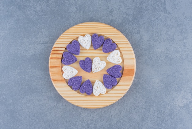 Biscotti a forma di cuore sul piatto, sullo sfondo di marmo.