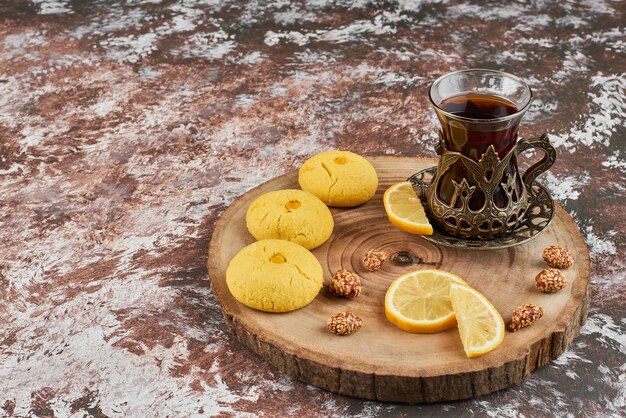 Biscotti al burro e un bicchiere di tè su una tavola di legno.