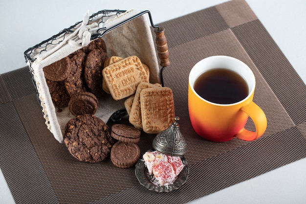 Biscotti al cacao e burro in un cestino con una tazza di tè