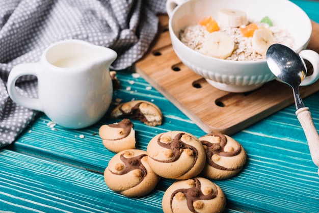 Biscotti al cioccolato con ciotola di farina d&#39;avena sul tavolo