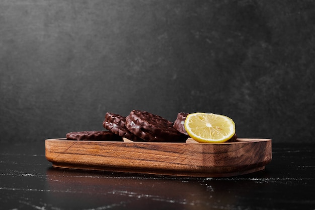 Biscotti al cioccolato con limone in un piatto di legno.