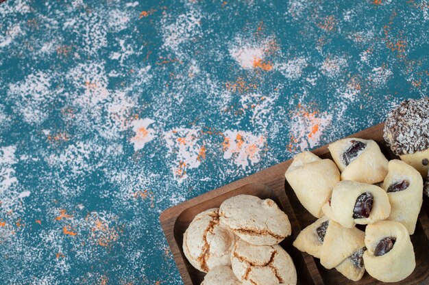 Biscotti al cioccolato e burro in una tavola di legno quadrata.