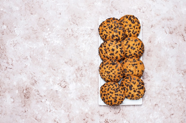 Biscotti al cioccolato in stile americano su sfondo di cemento chiaro.