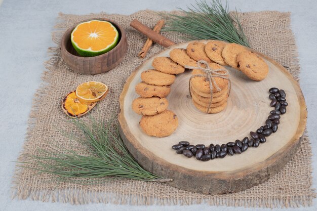 Biscotti al cioccolato su tavola di legno con cannella e fette di mandarino. Foto di alta qualità