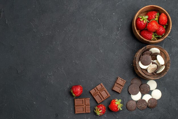 Biscotti al cioccolato vista dall'alto con fragole fresche su superficie scura