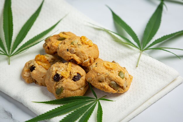 Biscotti alla cannabis e foglie di cannabis messi sul tovagliolo bianco