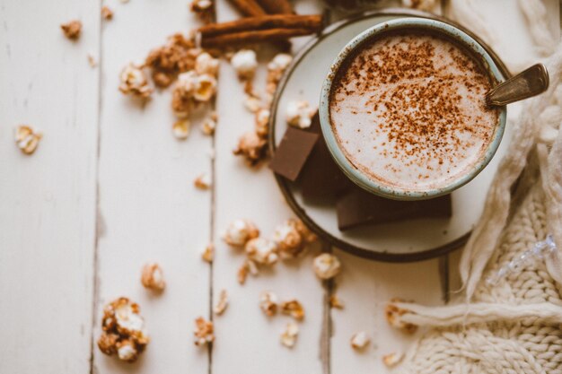 Biscotti allo zenzero con popcorn e cioccolato al cacao e coperta lavorata a maglia Accogliente sfondo della casa invernale